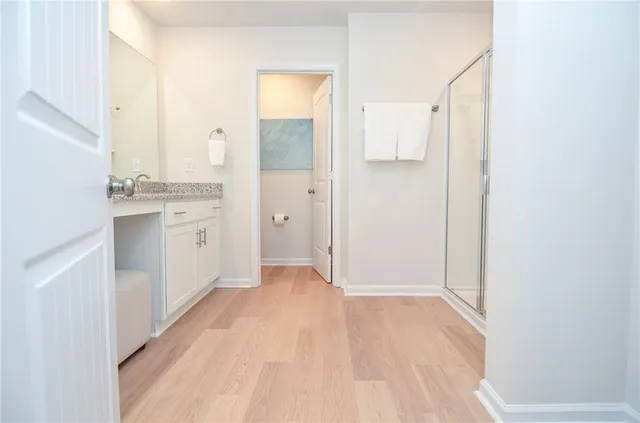 a en suite bathroom with a granite countertop sink and a mirror