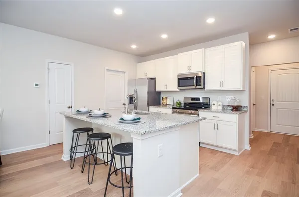 a kitchen with stainless steel appliances granite countertop a sink stove and refrigerator