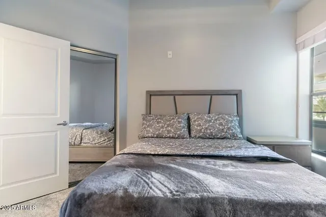 a bedroom with a large bed and a potted plant