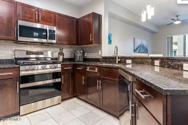 a kitchen with stainless steel appliances granite countertop a stove microwave and sink