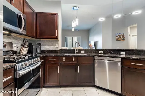 a kitchen with stainless steel appliances granite countertop a stove a sink and a microwave