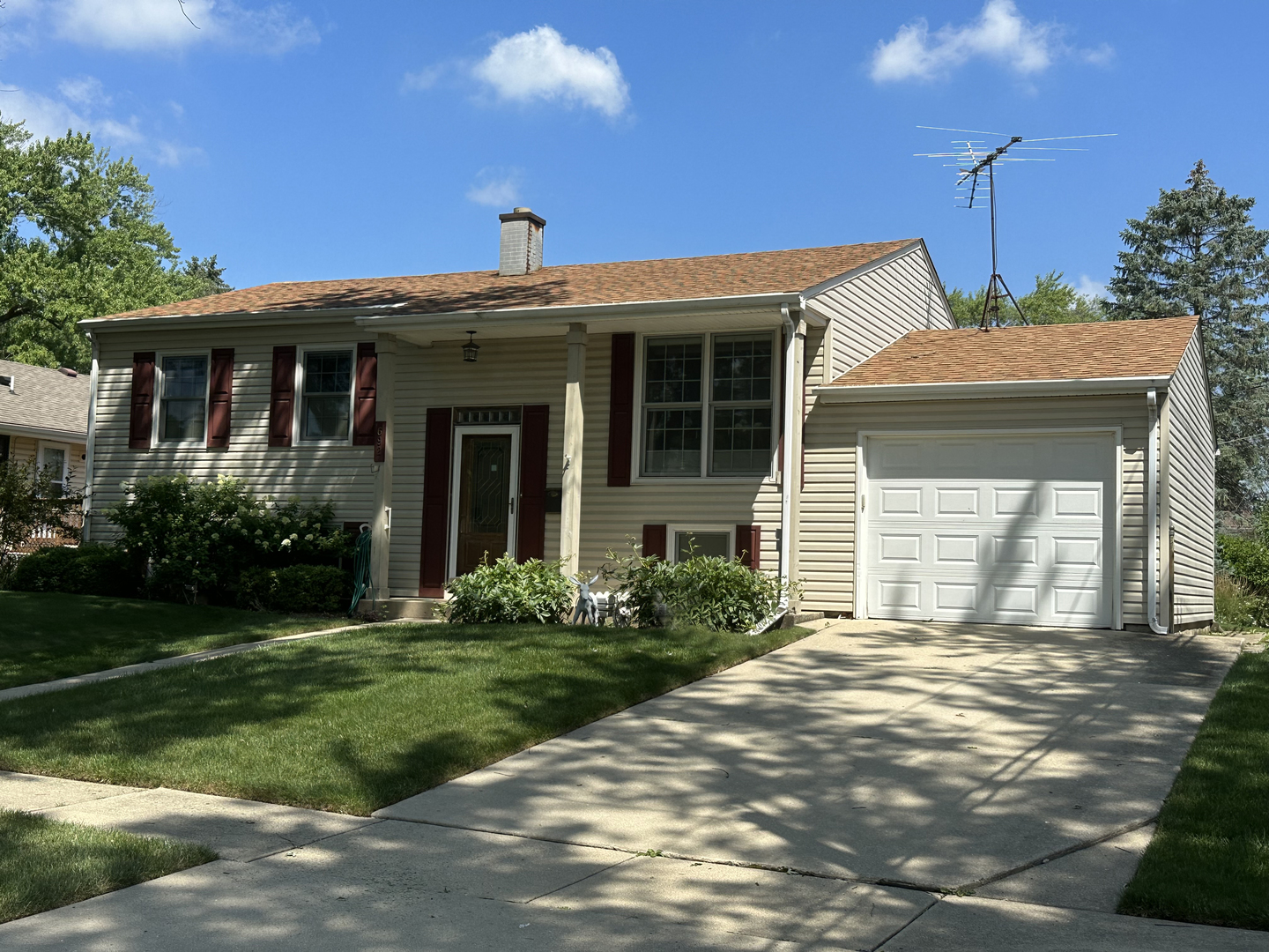 a view of a house with brick walls and a yard with plants