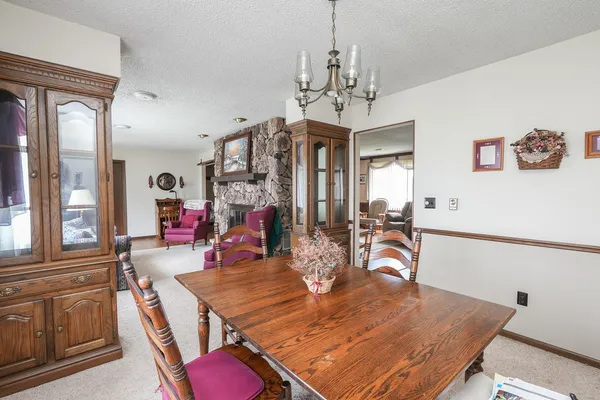 a large kitchen with stainless steel appliances kitchen island granite countertop a table chairs and a refrigerator