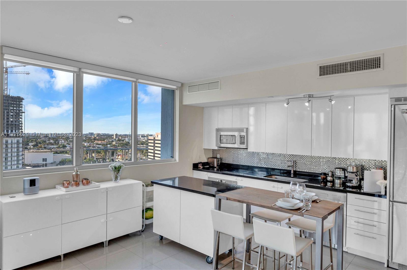 92 Southwest 3rd Street, Unit 1605 Miami, FL 33130 - Photo 13 of 37 a large white kitchen with a large window