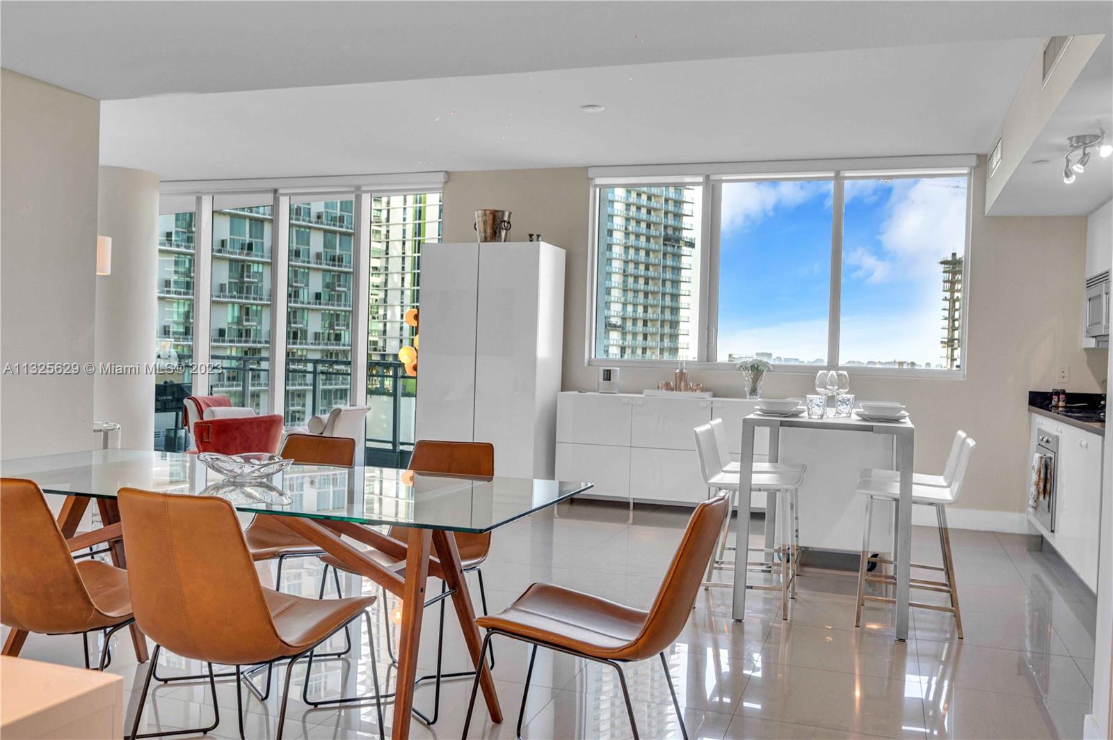 92 Southwest 3rd Street, Unit 1605 Miami, FL 33130 - Photo 16 of 37 a dining room with furniture and large windows