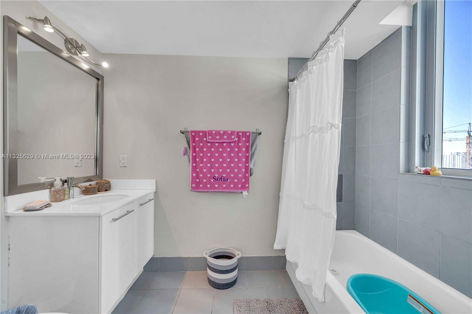 92 Southwest 3rd Street, Unit 1605 Miami, FL 33130 - Photo 21 of 37 a bathroom with a sink a toilet and shower curtain