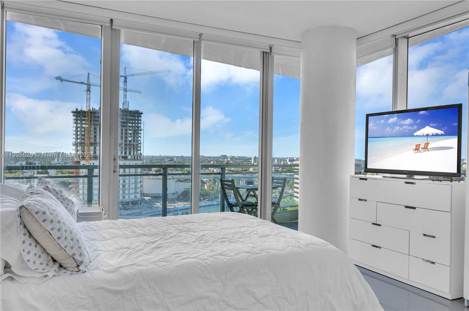 92 Southwest 3rd Street, Unit 1605 Miami, FL 33130 - Photo 24 of 37 a bedroom with a large bed and a flat tv screen