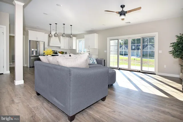 a living room with stainless steel appliances furniture and a chandelier