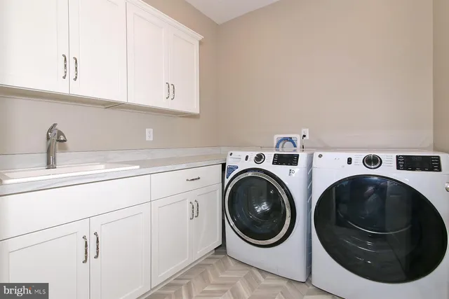 a utility room with sink dryer and washer