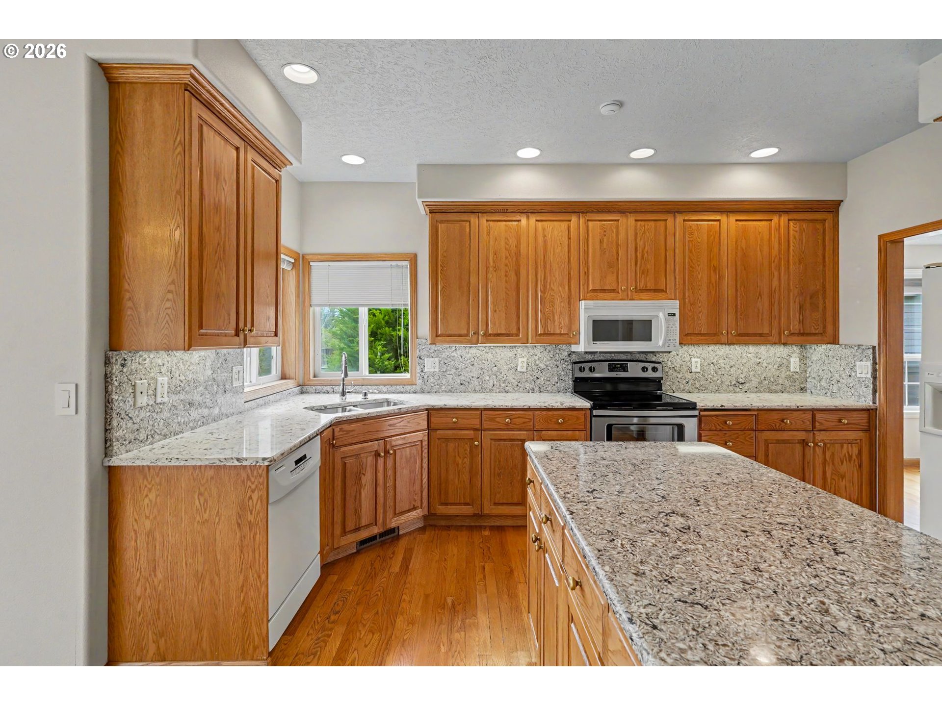 1470 Ranier Loop Northwest Salem, OR 97304 - Photo 16 of 48 a kitchen with stainless steel appliances granite countertop a sink stove and refrigerator