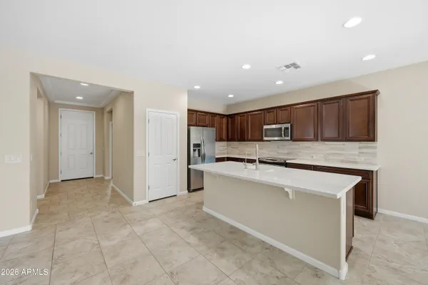 a large kitchen with stainless steel appliances granite countertop a large counter top and a stove top oven