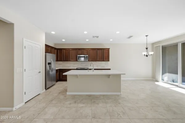 a view of kitchen with stainless steel appliances kitchen island granite countertop a stove and a sink