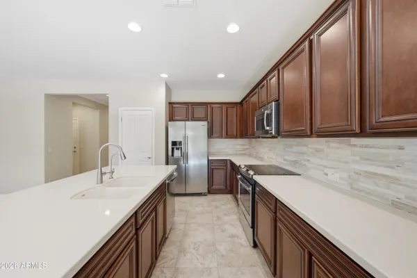 a kitchen with a stove a sink a counter top space and living room