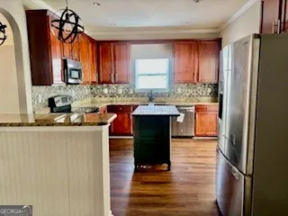 a kitchen with granite countertop wooden cabinets and stainless steel appliances