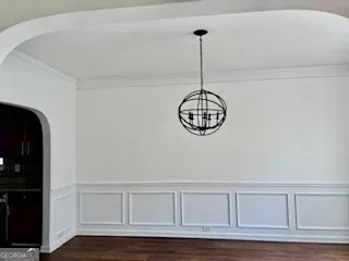 a view of a hallway with wooden floor and chandelier