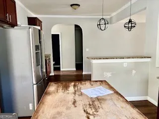 a kitchen with kitchen island granite countertop wooden cabinets and a refrigerator