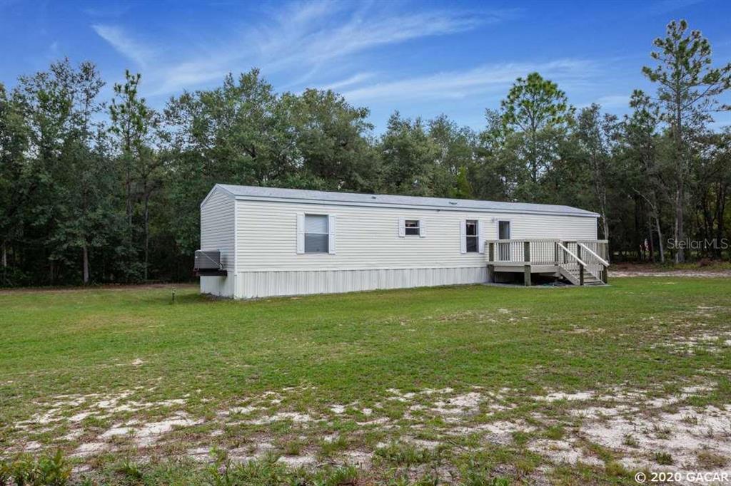 8096 County Line Road Melrose, FL 32666 - Photo 1 of 1 a view of a backyard with plants and a garden