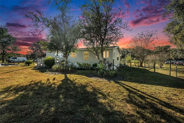 a front view of a house with a yard and mountain view