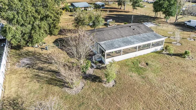 a aerial view of a house with a yard and flowers