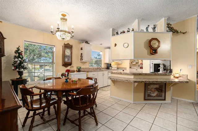 a dining table with a kitchen island and a chandelier