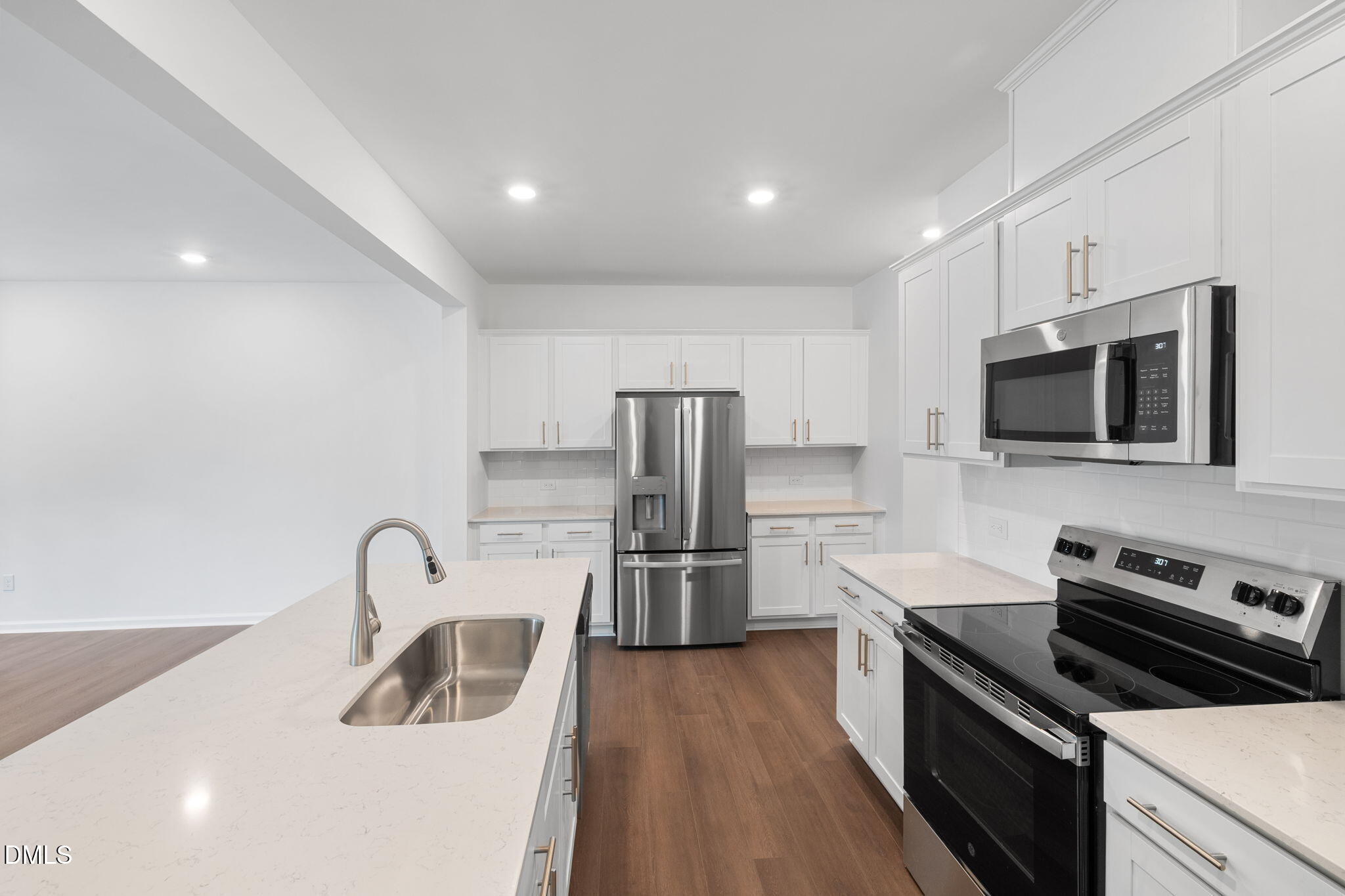 421 Deep Oak Drive, Unit SAWYER Rolesville, NC 27571 - Photo 7 of 16 a kitchen with stainless steel appliances a stove a sink a microwave and wooden floor