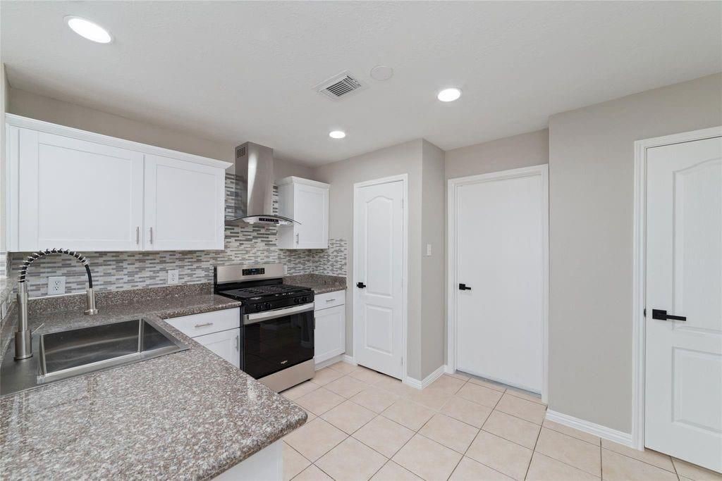 4007 Starbridge Pointe Lane Katy, TX 77449 - Photo 11 of 30 a kitchen with granite countertop a sink and stainless steel appliances