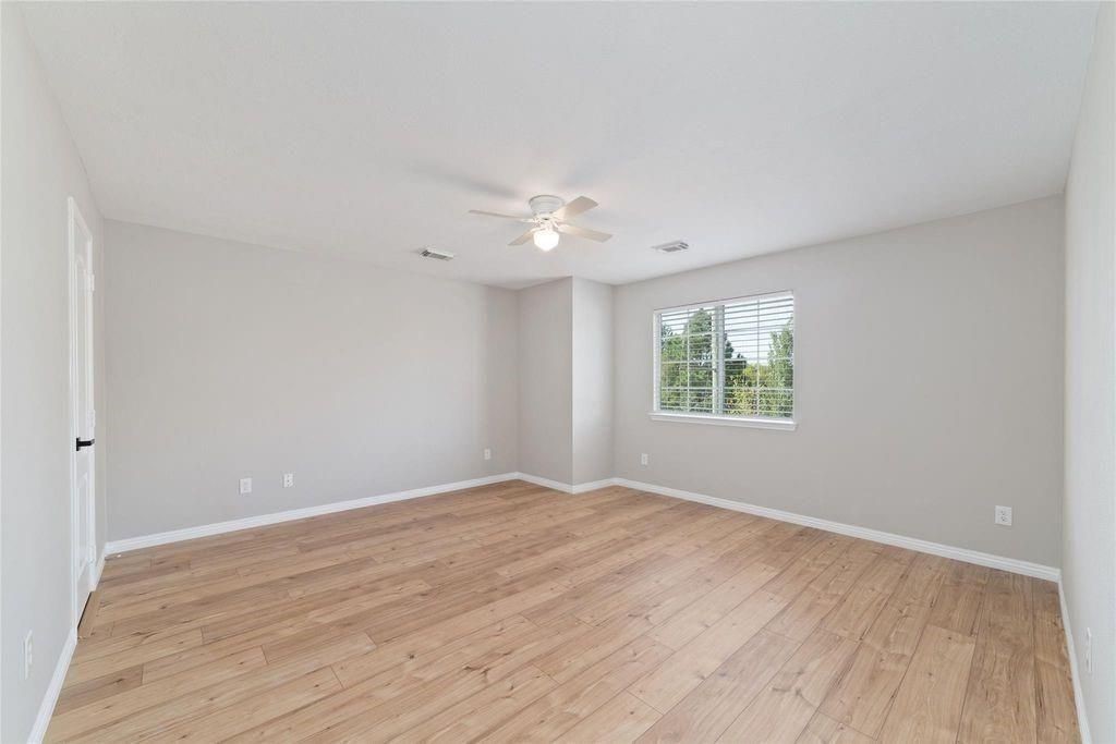 4007 Starbridge Pointe Lane Katy, TX 77449 - Photo 17 of 30 a view of an empty room with wooden floor and a window