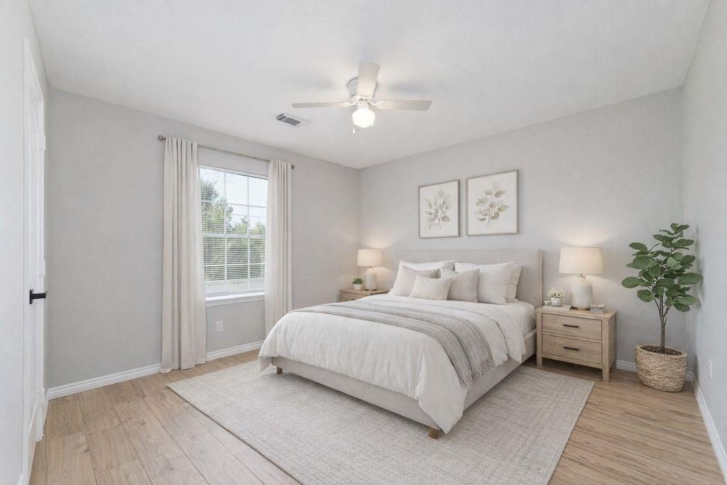 4007 Starbridge Pointe Lane Katy, TX 77449 - Photo 21 of 30 a bedroom with a large bed and a chandelier