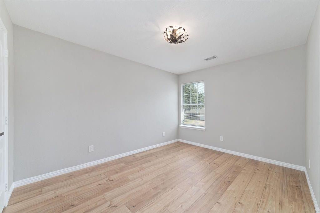 4007 Starbridge Pointe Lane Katy, TX 77449 - Photo 25 of 30 a view of an empty room with wooden floor and a window
