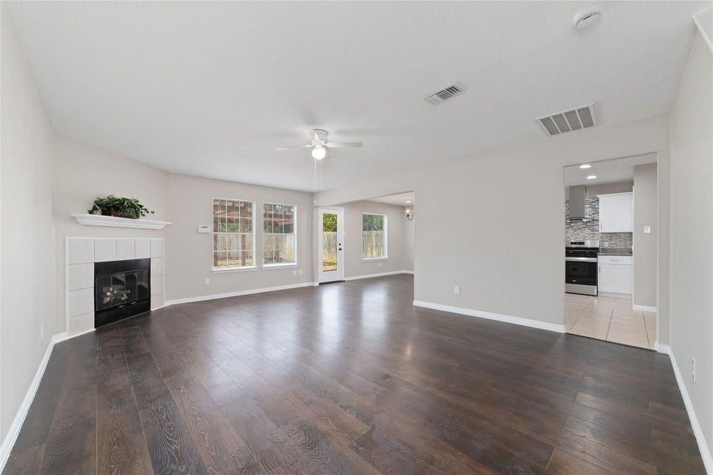 4007 Starbridge Pointe Lane Katy, TX 77449 - Photo 4 of 30 a view of an empty room with wooden floor and a fireplace