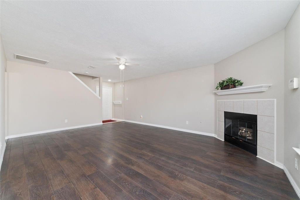 4007 Starbridge Pointe Lane Katy, TX 77449 - Photo 7 of 30 a view of an empty room with wooden floor fireplace and a window