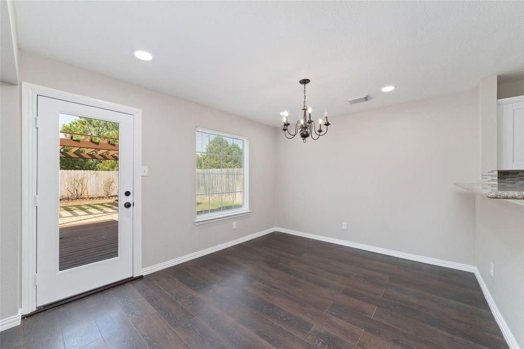 4007 Starbridge Pointe Lane Katy, TX 77449 - Photo 9 of 30 an empty room with wooden floor chandelier and windows