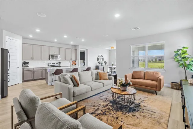 a living room with furniture kitchen and a table