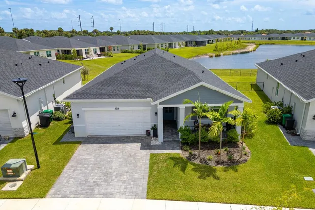 an aerial view of a house with a swimming pool a patio and yard