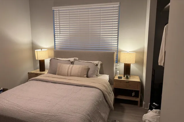 a bedroom with a bed and a night stand