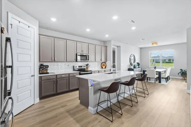 a kitchen with appliances cabinets and wooden floor