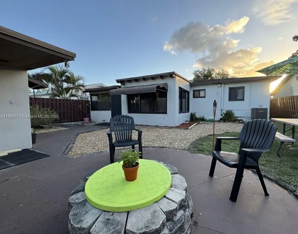 a backyard of a house with table and chairs