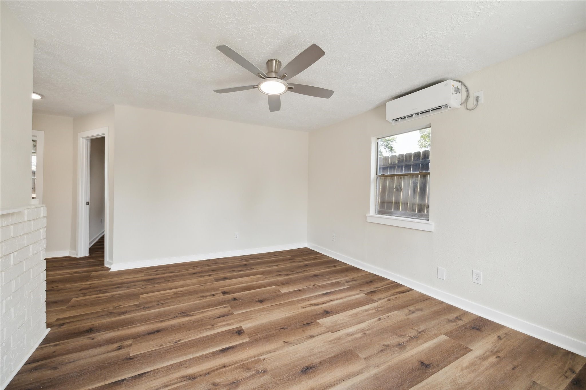 2802 Hardy Street, Unit C Houston, TX 77009 - Photo 4 of 18 an empty room with wooden floor fan and windows