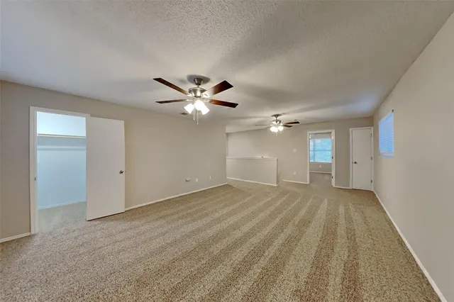 a view of an empty room with a chandelier fan