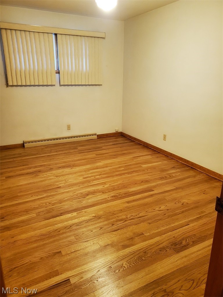 932 Pinecrest Road Girard, OH 44420 - Photo 13 of 25 Bedroom featuring baseboard heating and light hardwood / wood-style floors