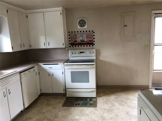 a kitchen with granite countertop a stove a sink and a microwave