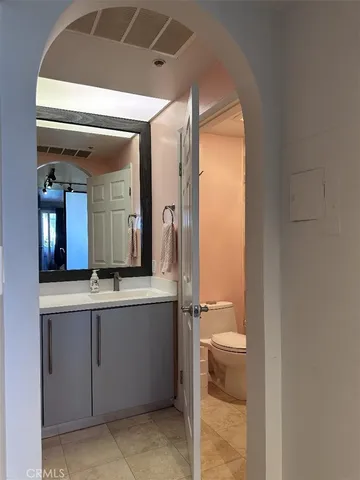 a bathroom with a toilet a sink and mirror