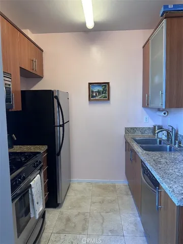 a kitchen with stainless steel appliances granite countertop a refrigerator and a sink
