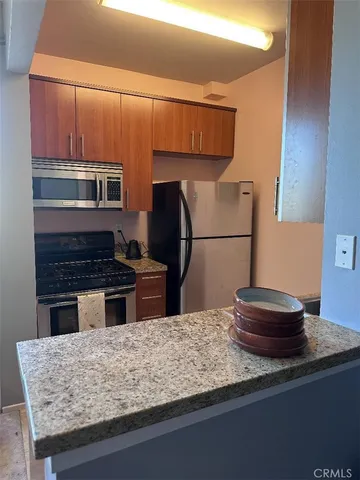 a kitchen with kitchen island a stove and a refrigerator