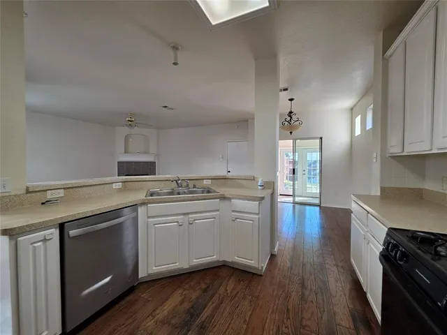 a kitchen with granite countertop a sink cabinets and stainless steel appliances