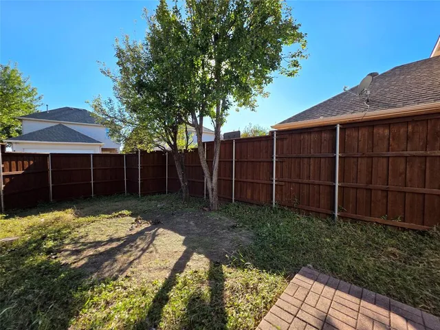 a view of a backyard with wooden fence