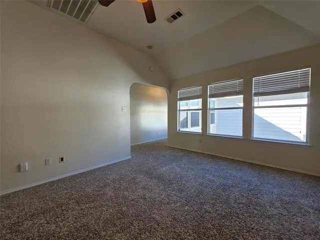 an empty room with closet and a chandelier fan