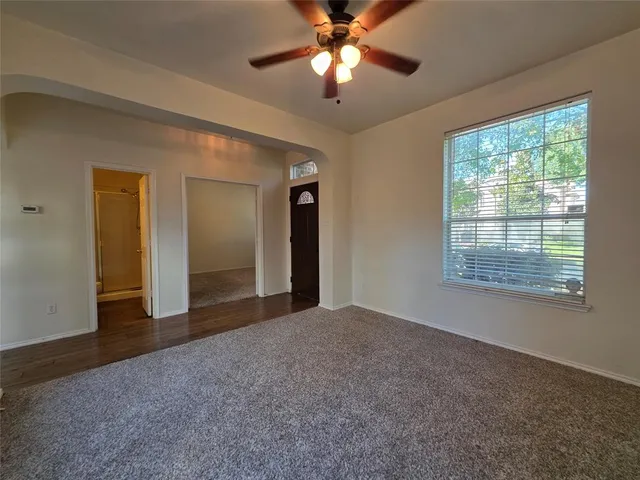 a view of a big room with windows and chandelier fan