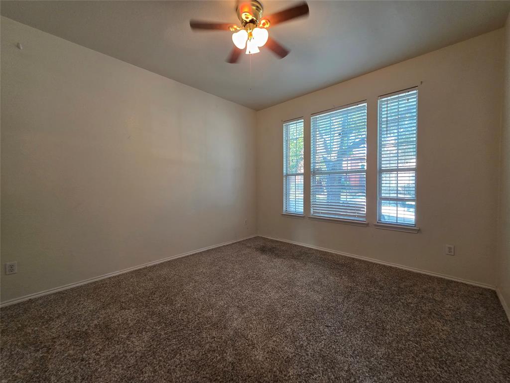 5413 Redwater Court The Colony, TX 75056 - Photo 8 of 40 an empty room with a chandelier fan and windows
