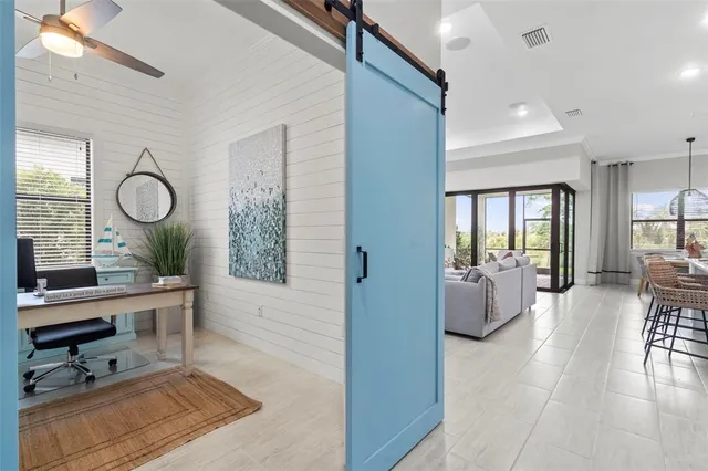 a kitchen with stainless steel appliances a dining table chairs refrigerator and microwave